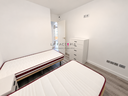 Dormitorio minimalista con dos camas.png