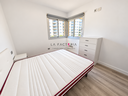 Dormitorio moderno con ventanas luminosas.png